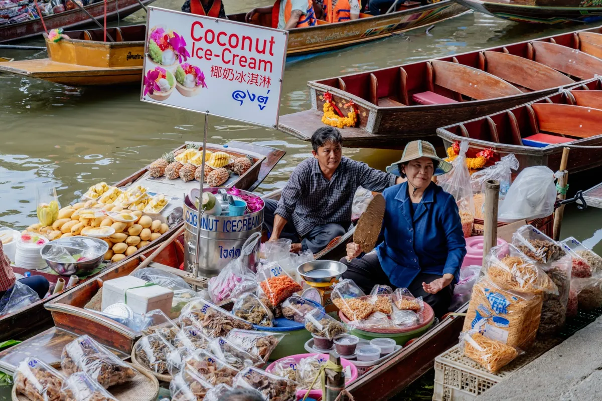 在丹嫩沙多水上市场从经过的小船上品尝美味的传统当地小吃