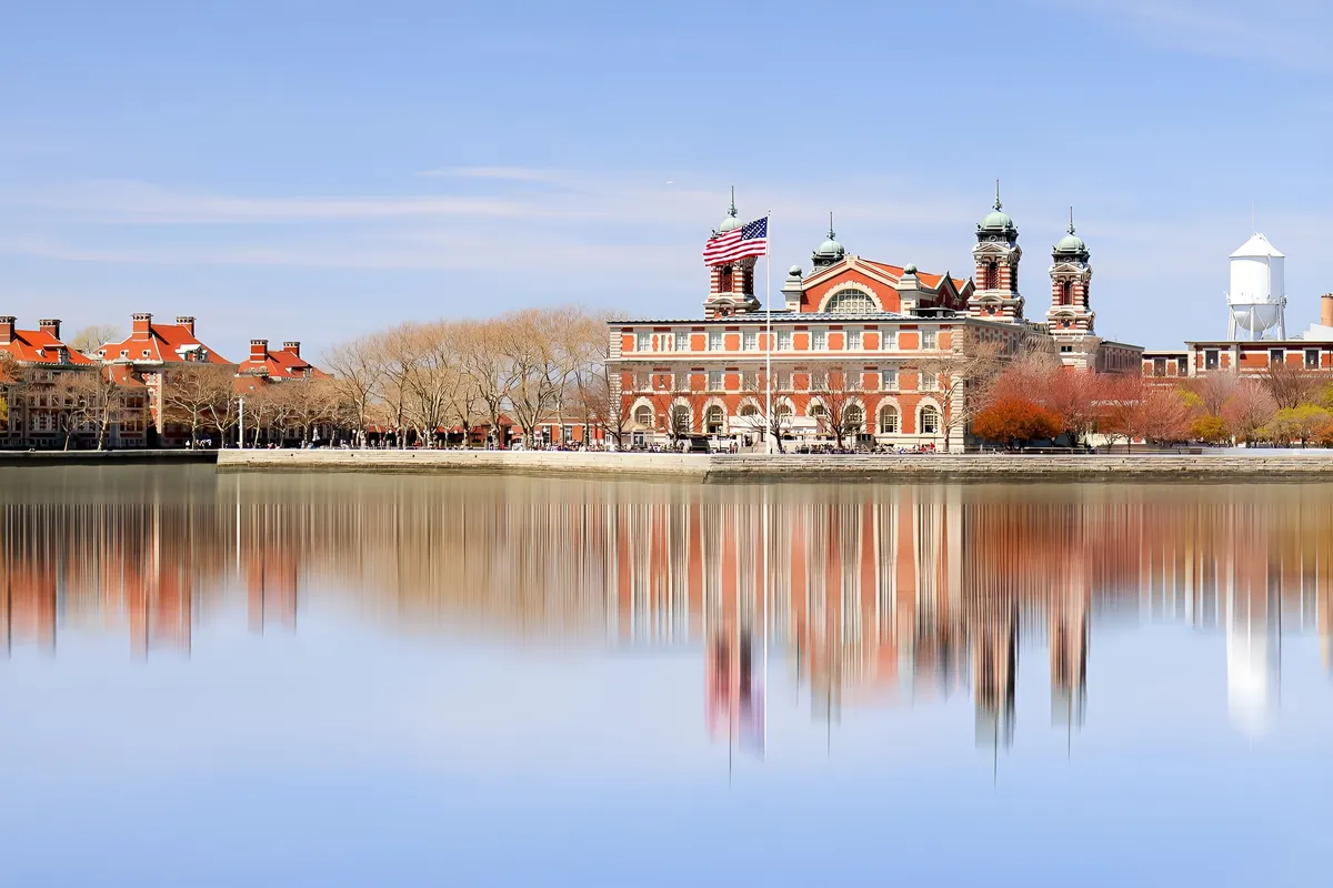 Pass by Ellis Island where immigrants from all over the world we processed before being admitted into the USA