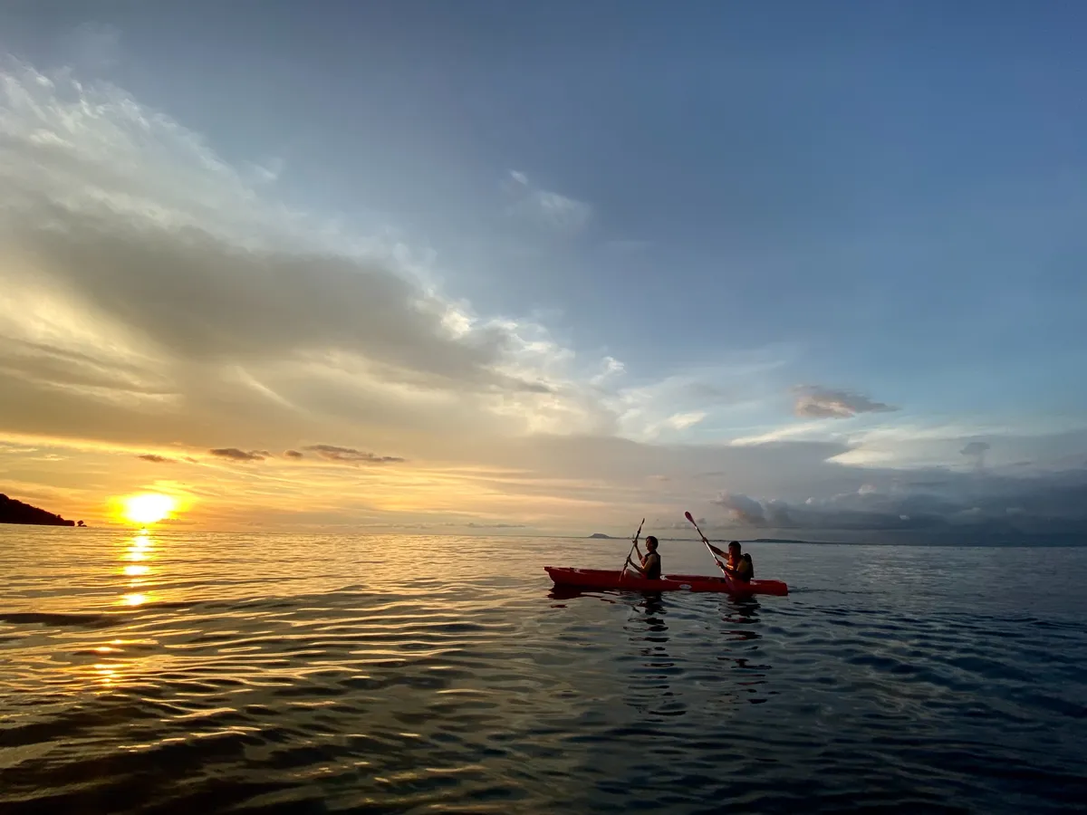 Paddle on the water while enjoying the beautiful sunrise in the sky.