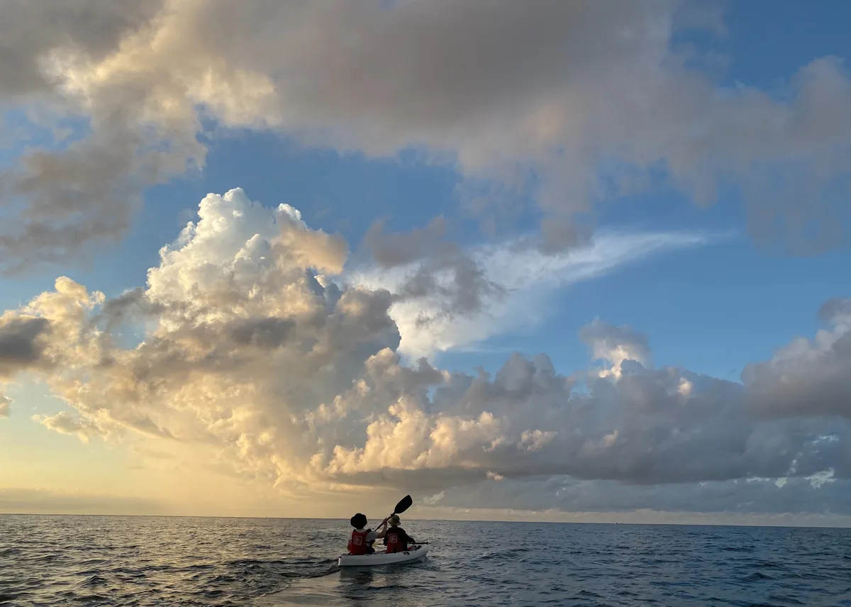Paddle on the water while enjoying the beautiful sunrise in the sky.