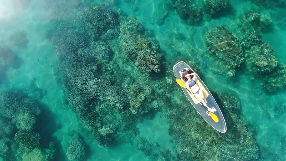 Erlebe den Nervenkitzel des Stand-up-Paddleboarding (SUP) auf dem klaren, türkisfarbenen Wasser!