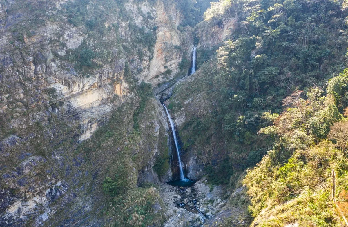 Shuanglong Waterfall is the source of the Zhuoshui River tributary, located in a stream between mountains. It cascades down steep cliffs, with a waterfall drop of approximately 100 meters, divided into upper and lower falls. It is named for its resemblanc