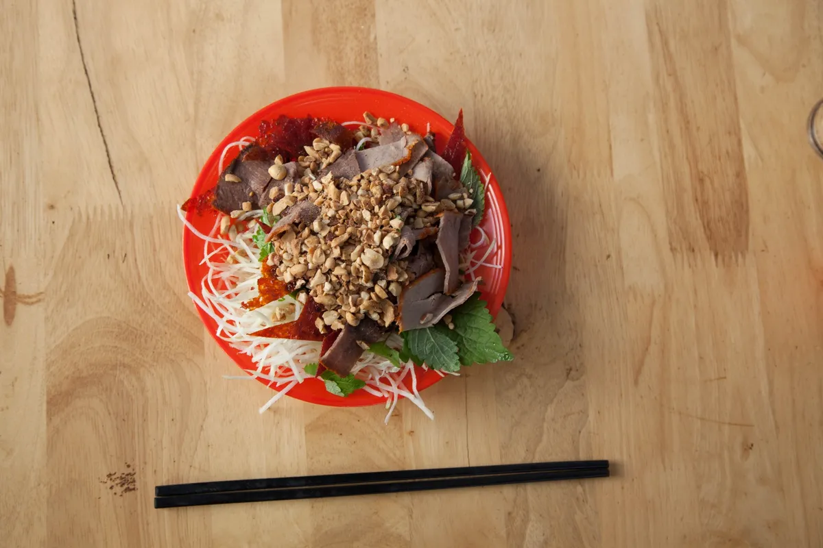 Appréciez les différentes textures des ingrédients du Nom Bo Kho, une savoureuse salade de bœuf séché